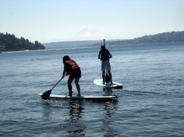 Stand-up paddleboarding against a backdrop of Mt. Rainier.